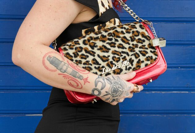  Hon har låtit tatuera en ros på handen, ett tändstift på överarmen och en och halvtumsnyckel runt handleden.