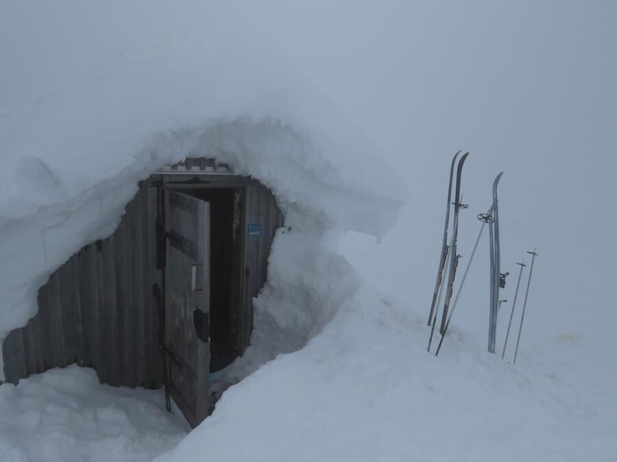 Här i detta hål i snön döljer sig vindskyddet vid Juovvatjåhkka, där sex människor räddade sina liv undan en snöstorm två veckor tidigare.