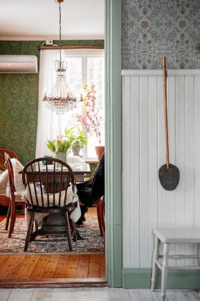  Den gamla pärlsponten i köket är fin mot den gråmönstrade tapeten. På väggen hänger en gammal flugsmälla av skinn.