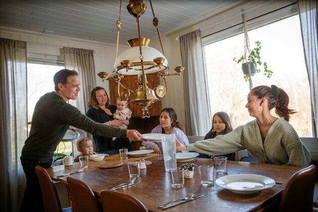  Fredrik dukar till middag för deras stora familj. 3-årige Helge sitter till bords, lilla Kerstin är i mamma Elins famn och sedan döttrarna Stina, Siri och Magda. 