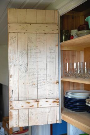  På insidan av dörren till ett av köksskåpen har tidigare generationer på sätern skrivit hälsningar och små verser.